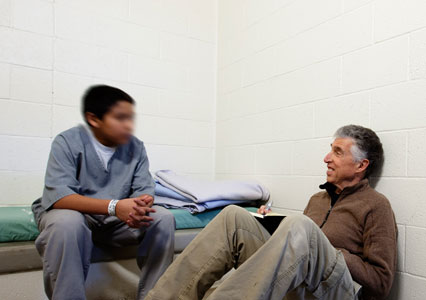 Young man in cell interacting with older man
