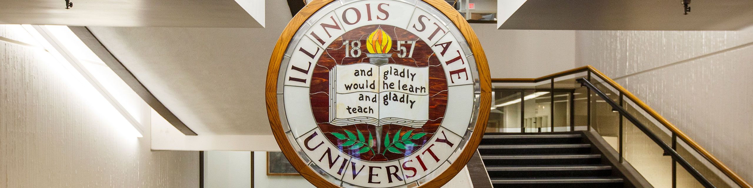 Illinois State University seal with the words Gladly We Learn and Teach.